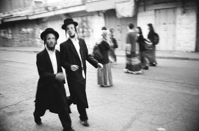 HEBRON, ISRAEL, 1995 Visiting Hasidic Jews stroll freely through the Jewish section of Hebron, the contested land in Israel’s West Bank. © Ed Kashi - Courtesy Kehrer Verlag
