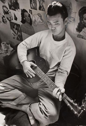 (Young man playing guitar in the stockade, Tule Lake Internment Camp, Newell, California), 1944 Carl Mydans (American, born in 1907) Photograph, gelatin silver print * International Center of Photography, the LIFE Magazine Collection, 2005 * Photo by Carl Mydans. © LIFE Picture Collection * Courtesy Museum of Fine Arts, Boston