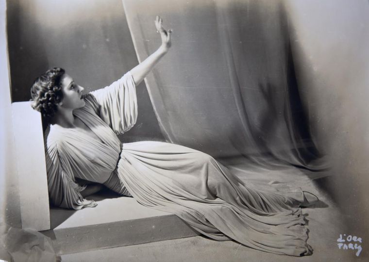 © Madame d'Ora - Vintage, signed black and white silver print (sepia) full frame depicted a model wearing a pleated Alix dress. The artist is noted by the signature written in the lower right-handed corner. , 1936 - Courtesy of Foundation Azzedine Alaïa & SCAD FASH Museum of Fashion + Film