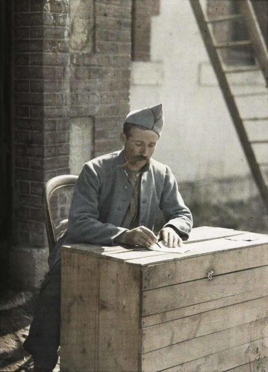 Fernand CUVILLE - Poilu faisant sa correspondance sur une caisse en bois, 1917 © Ministère de la Culture - Médiathèque du patrimoine et de la photographie, Distr. RMN-Grand Palais