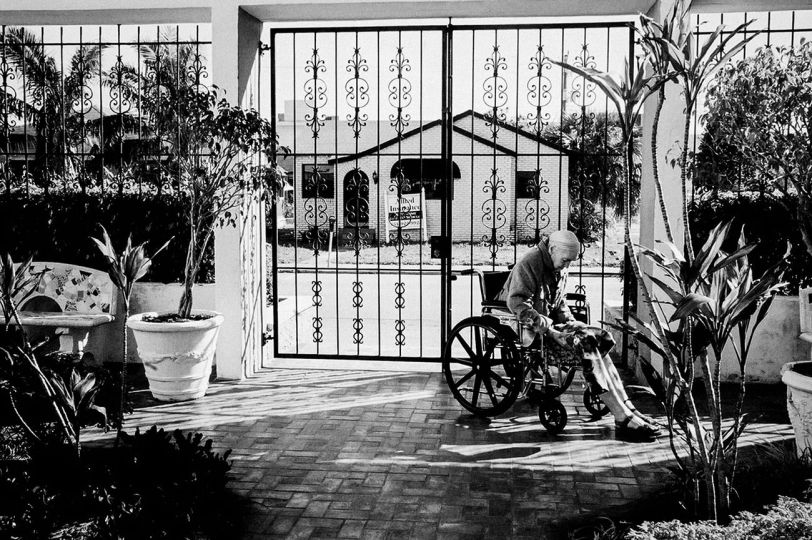 Madje Steber, after living in two assisted living facilities in the Miami area, finally finds the right place at midtown manor. She sits in the garden courtyard of her new home in Hollywood, Florida. 2007. © Maggie Steber - Courtesy Leica Gallery Los Angeles