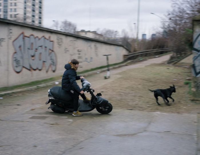 Paris, 9 janvier 2020. En contrebas du périphérique, dans une ancienne station de service, est établi un camp d'une quarantaine de Roms. Rev s'amuse avec un scooter devant le camp. © Audrey Delaporte