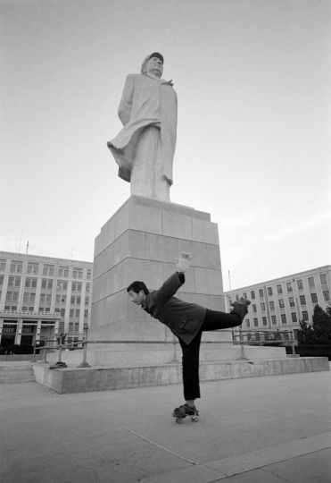 A student at the Dalian Institute of Technology skates past a statue of Chairman Mao. Dalian, 1981. © HS Liu