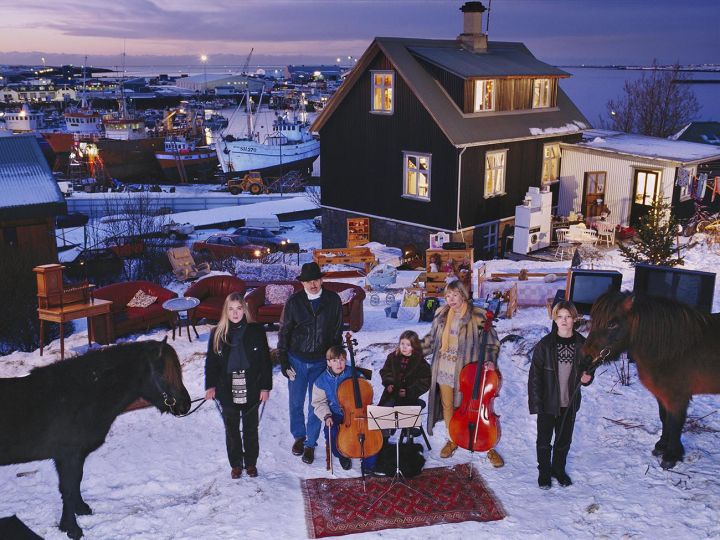 The Thoroddsen family of Hafnarfjörður, Iceland, photographed with all their possessions outside of their suburban home by Peter Menzel at 4 pm, December 15, 1993. 
The family lives in a wood-framed house overlooking the nearby harbor, 10 km from Reykjavik. Björn (Bennie) is a pilot for Iceland Air and Margret (Linda) Gunnlaugsdöttir, a former flight attendant, is now a milliner. Most valued possessions: Hand-built airplane (father); cello (mother); horse (elder daughter); knife (elder son); and antique pistol (younger son).  © Peter Menzel 
