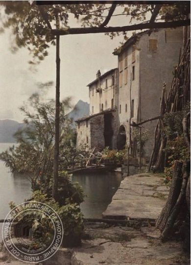 Louise Deglane, Gandria [Maisons au bord du lac de Lugano, barque, montagnes, pergola, Tessin, Suisse], 1912. Plaque de verre Autochrome, 9 x 12 cm © SFP