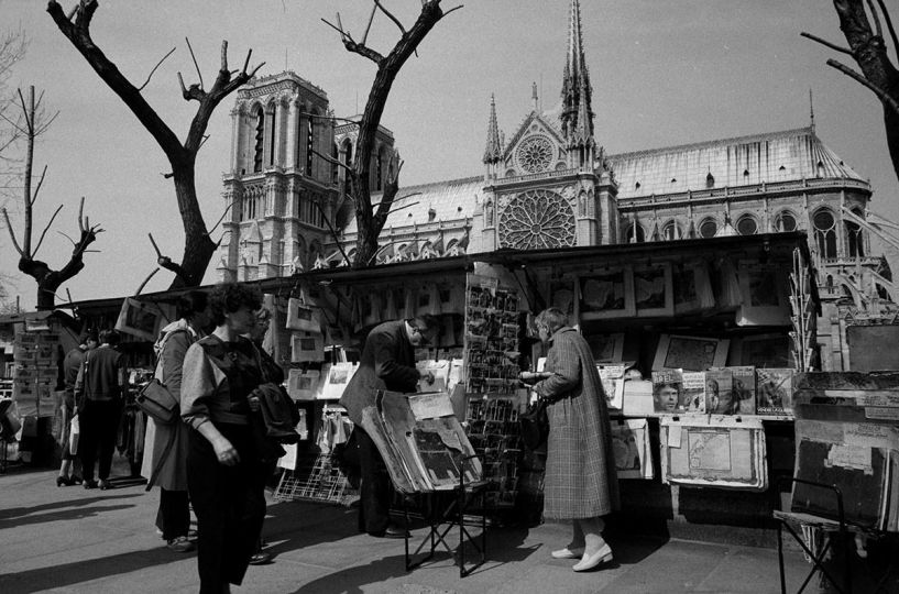 Bouquinistes, quai de Montebello, et la cathédrale Notre-Dame. Paris, 1984. Photographie de Janine Niepce (1921-2007). © Janine Niepce / Roger-Viollet