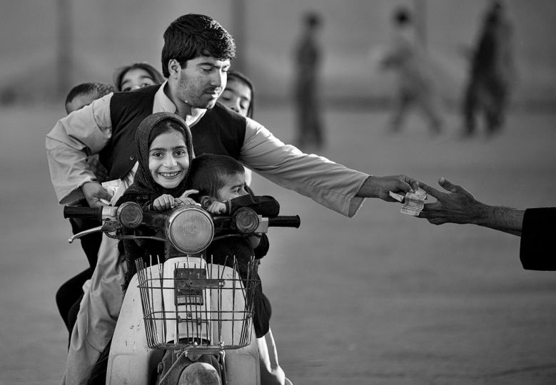 An Afghan man with his five children on his motorbike pays money to enter a park in Kandahar, southern Afghanistan, Friday, Nov 1, 2013. On Friday’s, the Islamic sabbath, children and their families traditionally gather in one of the few parks. © Anja Niedringhaus / AP Photo