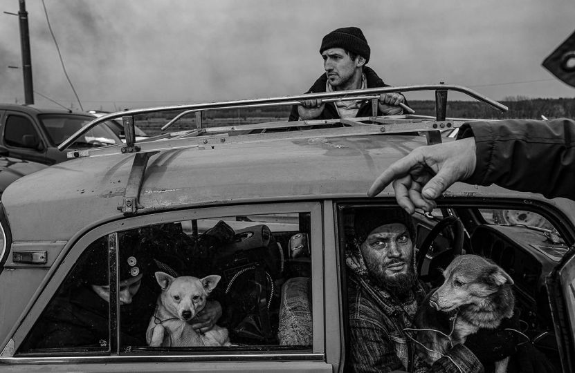A group of Ukrainian IDPs who fled Irpin, a suburb of Kyiv that has seen heaving fighting and shelling, arrive at an area before the destroyed bridge into the city during in the third week of the Russian invasion. March, 2022. © Byron Smith - From the book Testament ’22 - Courtesy Verlag Kettler
