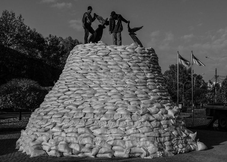 Civilians pad a monument dedicated to soldiers lost since the war began in 2014 in Mykolaiv in as the Armed Forces of Ukraine push deeper into Russian occupied Kherson oblast on November, 2022. © Byron Smith - From the book Testament ’22 - Courtesy Verlag Kettler