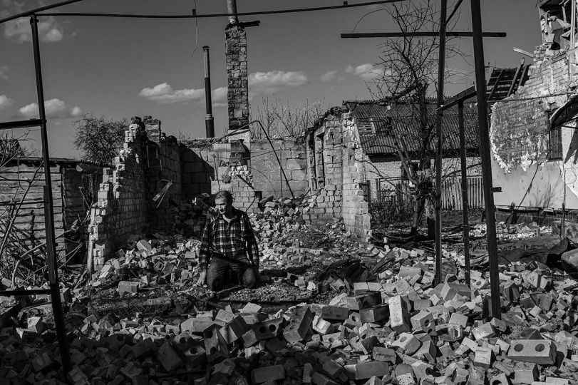 Serhiy 56, spends the afternoon helping his elderly neighbors recover buried tools in the rubble of their home to rebuild their house in Chernihiv on April 28, 2022. The city, with a population of 285,000, had been under siege for 39 days and killed 700 people, according to the city’s mayor. © Byron Smith - From the book Testament ’22 - Courtesy Verlag Kettler