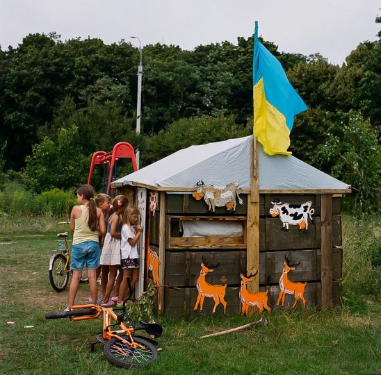 Children play in a clubhouse made from abanonded Russian ammunition crates. Chernihiv, June 2022. © Byron Smith - From the book Testament ’22 - Courtesy Verlag Kettler