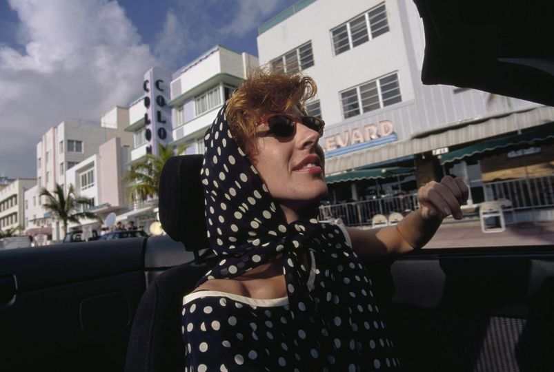 Artist Laura DePasquale drives down Ocean Drive, the heart of the Art Deco area in South Beach. Miami drew many young artists who hoped to make a life for themselves there. For years this area fell into disrepair and was where elderly people came to escape the cold winters.
But with the refurnishing, the area became fashionable and younger people were drawn to the Art Deco architecture and art and color and convertibles and the promise of a full and exciting life. © Maggie Steber