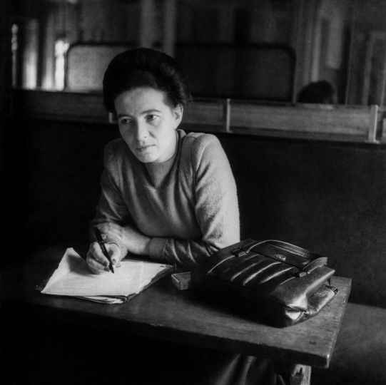 Simone de Beauvoir, femme de lettres française (compagne de Jean-Paul Sartres) ; Paris 9.1.1908 – id. 14.4.1986. Simone de Beauvoir, écrivant, attablée au Café de Flore à Paris. © Denise Bellon