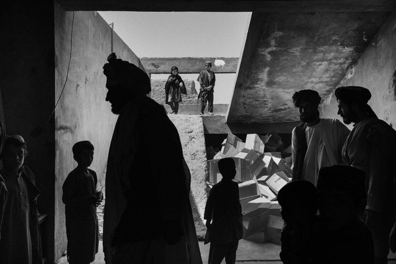 Sangin, Afghanistan, June 2022: Patients and family members crowd the entrance of Sangin’s clinic. The clinic is housed in a dilapidated building whose construction was never completed. Sangin is a small town in Helmand province, in the south of the country, and was the scene of heavy fighting during the war. These rural areas are now safer than they were at the height of the conflict, but still endure extreme poverty. © Lorenzo Tugnoli