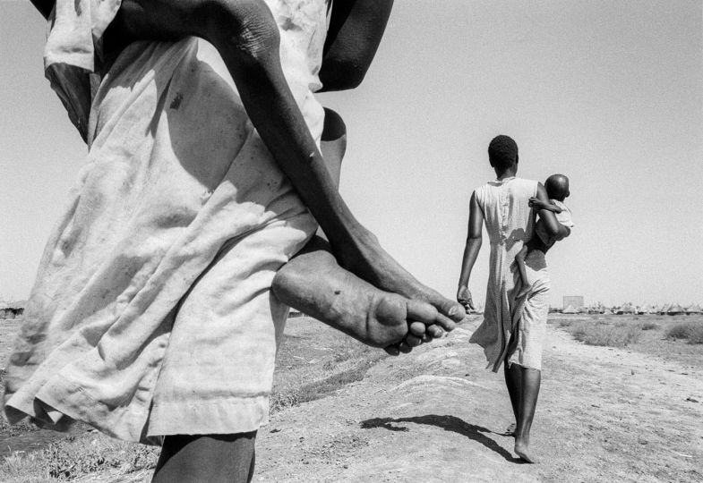 SUDAN. Kosti. 23/10/1988: South Sudanese displaced. Most of the malnourished children are too weak to walk the 300 m to the feeding center and have to be carried there. © John Vink