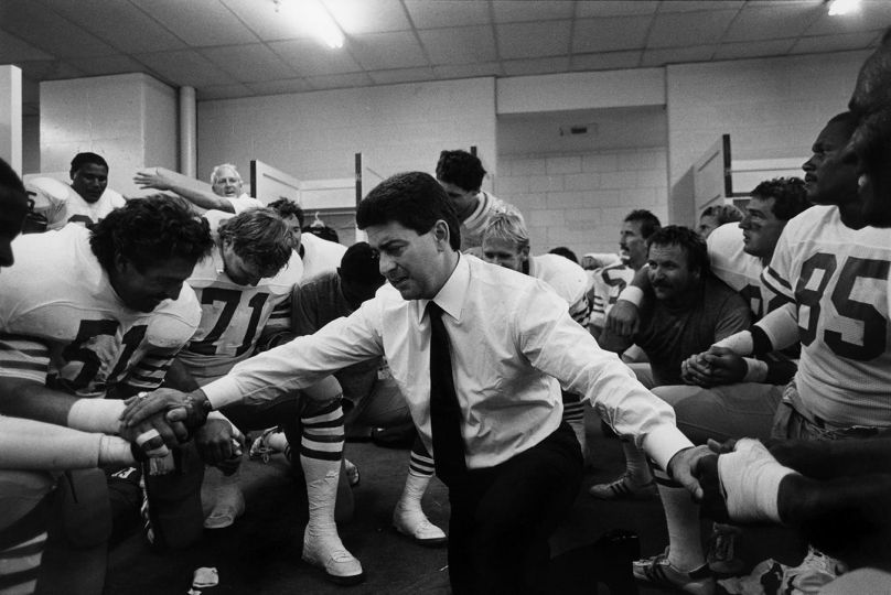 Michael Zagaris - Eddie DeBartolow owner of the 49ers prays with the team after they beat the Cincinatti Bengals, 1987 © Michael Zagaris